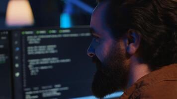 Joyous remotely working programmer in home office doing coding on computer at desk. Upbeat teleworking IT professional in apartment writing lines of code at workstation, camera A close up shot photo