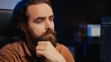 Software technician puzzled in front of computer screen while writing complex code, thinking of solution. IT expert feeling confused while trying to solve database bugs, camera B close up photo