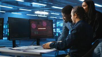 System administrator in server room workplace requesting assistance from colleagues during malware attack. IT support worker asking for help from colleagues to protect data center from hackers photo