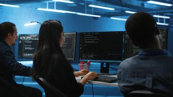 Multiethnic team of engineers working in high tech server hub, using PCs to analyze data. Multiracial group of employees examining infrastructure in data center, ensuring system integrity and security photo