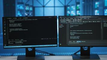 Computers in empty data center facility managing rackmounts energy consumption. Close up of script on PC monitors used for automation and monitoring processes in server room, camera B photo