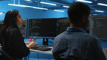 Woman talking in headphone mic, doing system analysis of server farm supercomputers. IT support worker in remote call using headset microphone in data center housing storage infrastructure photo