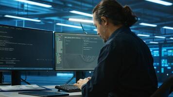 System admin focused on programming in server room housing advanced equipment storing massive datasets. Developer typing code on PC to mend data center racks doing complex computational operations photo