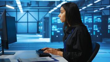 IT engineer looking at PC screen, working in network security data center, ensuring optimal performance. Woman monitoring energy consumption across operational server rigs components, close up shot photo
