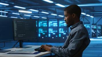 Software developer programming in high tech facility with server rows providing computing resources for different workloads. IT expert supervising data center supercomputers photo