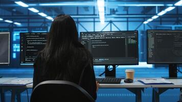 IT support employee in data center putting headphones on to talk with coworkers, coding on computer. Woman in remote call meeting with colleagues using headset microphone, overseeing server clusters photo