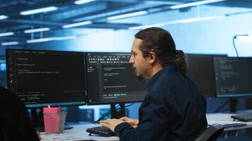 Knowledgeable engineer upgrading equipment in data center, zoom in shot. Specialist at PC desk in high tech establishment overseeing server rows, typing on keyboard, close up shot photo