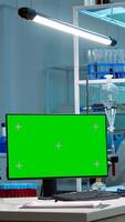 Team of scientists working in background of modern laboratory using computer with green screen, mockup display, chroma key monitor, analysing experiment evolution, high tech development lab. photo