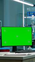 Computer with green screen working in labooratory with mock up monitor, chroma key display while professional engineer testing virus evolution in background. High tech development lab. photo