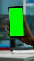 Chroma key isolated display on smartphone used by scientist woman in lab cabinet and colleagues in white coat bringing blood sample. Scientist using mobile phone with mockup green screen photo