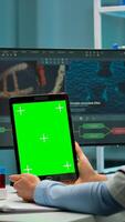 Medical research laboratory portrait of female scientist holding tablet with green chroma key screen. Advanced scientific lab for medicine, biotechnology working for vaccine development. photo