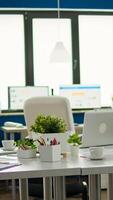 Business office with nobody in it, ready for brainstorming, meeting room equipped with modern devices, financial graphs loading on monitor. Empty start up company with no people in it photo