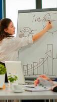 Focused team leader presenting marketing plan to interested multiracial coworkers. Serious speaker boss executive, business trainer explaining development strategy to motivated mixed race employees. photo