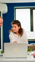 Multiethnic businesspeople meeting brainstorming, team leader sharing creative ideas planning development strategy using laptop technology in office workplace. Manager briefing diverse teamworkers photo