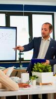 Manager pointing on digital interactive whiteboard with growth analysis, charts, statistics and data. Diverse people working in broadroom during conference meeting discussing company problems. photo