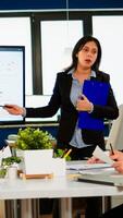 Female project manager holding financial meeting showing statistical graphs and charts on interactive whiteboard touchscreen device. Executive director working in broadroom of creative agency. photo