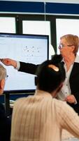 Diverse business people, staff group, sitting at desk in office, discussing about financial problems. Executive manager showing a presentation on digital interactive whiteboard with growth analysis photo