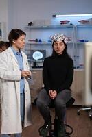 Neurologist doctor showing tomography expertise to woman patient with eeg scanner during neurology experiment in lab, Specialist doctor analyzing brain evolution monitoring nervous system activity photo