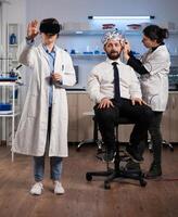 Researcher woman wearing virtual reality headset during neurology experiment in medical laboratory. Neurologist doctor adujusting eeg scanner monitoring brain activity analyzing nervous system photo