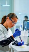 Scientist in modern equipped medical laboratory examinining drug discovery with micropipette. Medical stuff examining vaccine evolution using high tech and technology researching treatment, development against covid19 photo