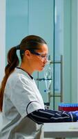 Team working to develop a new vaccine in modern equipped laboratory, woman typing at computer. Group of biochemistry scientists examining virus evolution using high tech for researching treatment photo