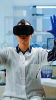 Professional scientist wearing virtual reality glasses using medical inovation in lab. Team of researchers working with equipment device, future, medicine, healthcare, professional, vision, simulator photo