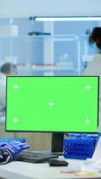 Medical research scientist working on pc with green screen mock up template in applied science laboratory. Engineers conducting experiments in background, examining vaccine evolution using high tech photo