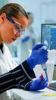 Research scientist using micropipette to extract blood sample on petri dish analysing chemical reaction sitting in laboratory. Doctor examining virus evolution using high tech and chemistry tools photo