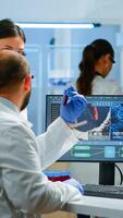 Group of scientists working in modern equipped laboratory pointing on computer desktop. Team of doctors examining vaccine evolution using high tech researching diagnosis against covid19 virus photo