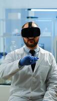 Professional scientist using medical inovation in lab wearing virtual reality glasses, gesticulating. Team of researchers working with equipment device, future, medicine, healthcare, vision, simulator photo