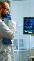 Team of chemists working with DNA scan image looking at desktop standing in medical research laboratory, analysing biochemicals samples, talking. Microbiology development with advanced equipment photo