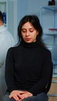 Team of scientists doctor discussing health status of patient, brain functions, nervous system, tomography scan while woman waiting for diagnosis of disease sitting in neurological research laboratory photo