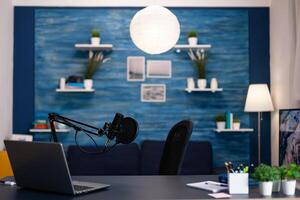 Empty podcast studio with nobody in it equipped with professional production podcasting equipment ready for entertainment vlog. Digital web internet streaming station. On-air show in living room photo