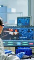 Team of scientists worried about virus evolution discussing in equipped laboratory pointing at computer. Stuff examining vaccine development using high tech researching treatment against covid19 virus photo
