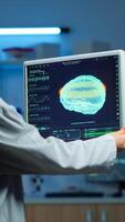 Neurologist doctor reading informations of patient looking at monitor analysing brain scan discussing with patient wearing eeg headset. Scientist taking notes examining nervous system of woman in lab photo