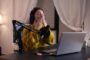 Woman vlogger blowing kisses at camera for fans while recording livestream answering listeners questions in studio at home. Social media influencer hosting online entertainment vlog. On-air show photo
