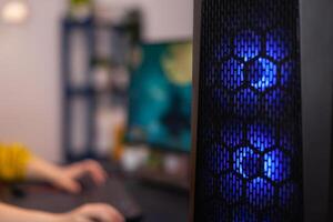 Closeup of RGB led lights powerful computer, woman gamer playing space shoother videogames during online competition. Gaming studio equipped with professional streaming setup photo