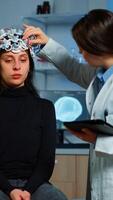Professional doctor in neuroscience developing treatment for neurological diseases examining patient evolutions. Doctor researcher adjusting EEG headset analyzing brain functions and health status photo