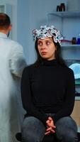Expert medic in neuroscience developing brain experiment holding laptop explaning to woman side effects of nervous system treamtment. Team of scientists working in neurological research laboratory photo