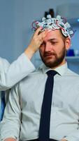 Neurologist doctor analysing brain of man and nervous system using brainwave scanning headset. Researcher using high tech developing neurological innovation monitoring side effects on monitor screen photo