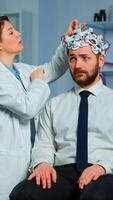 Patient with brain scan discussing with researcher neurological doctor while adjusting brainwave scanning headset examining diagnosis of disease, explaning eeg results, health status, brain functions photo