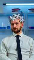 Researcher neurologist doctor asking man's symptoms taking notes on clipboard before brain scan with brainwave scanning headset. Scientist analyzing health status, nervous system, tomography scan photo