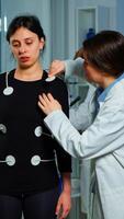 Scientist researcher preparing woman patient for endurance test attaching electrodes on professional body equipment. Team of doctors monitoring health of patinet, vo2, ekg scan runs on computer screen. photo