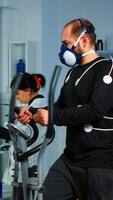 Sportsman running on cross trainer in lab facility for sports performance, medical researcher monitoring endurance and heart rate. Monitor showing EEG, EKG reading of athlete running on cross trainer photo