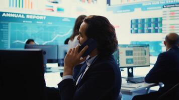 Chief financial officer sharing firm progress on a phone call with the main investor, ensuring performance based on current situation. Administrator works to expand enterprise budget. Camera B. photo