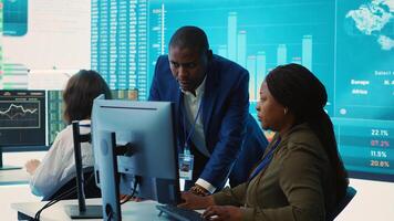 Financial analyst works on resource allocation plans with his staff, analyzing reports and sales infographics to find revenue. Achieve objectives in a competitive business environment. Camera A. photo