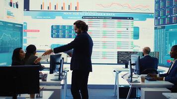 Financial manager briefing his team members about new corporation objectives, presenting their budget scheme with expenses. Resource allocation and project planning in control room. Camera B. photo
