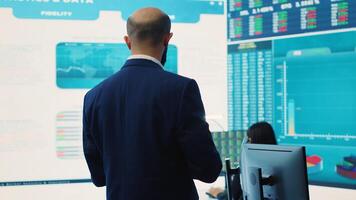 General director employing big data to help in solving tasks in control room, operating on huge screen to create a performance metrics analysis. Manager ensuring organizational efficiency. Camera A. photo