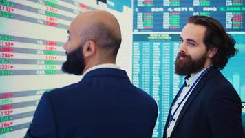 General manager and CEO sharing insight about a new development strategy with data on a big screen, presenting annual infographics to analyze business activity status. Investors team. Camera B. photo