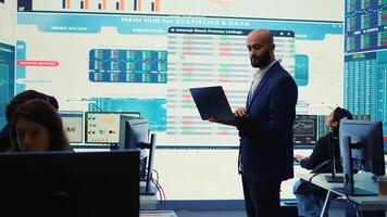Business investor reviewing latest budgeting plans on a big screen with data reports, collecting details about financial updates to ensure global expansion. Shareholder making decisions. Camera B. photo